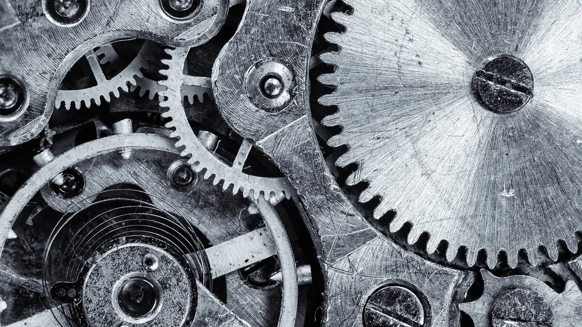 Close-up black and white macro of intricate interlocking metallic gears and clockwork mechanism.
