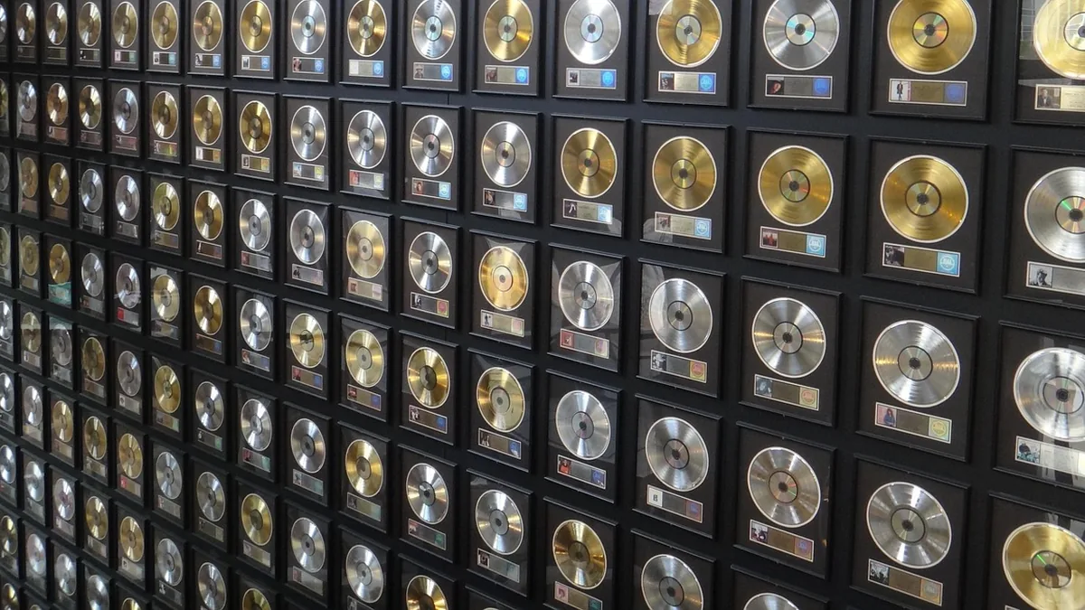 A wall covered in many framed gold and platinum music awards.
