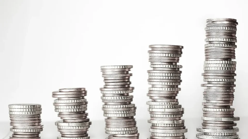 Stacks of silver coins rising in height like a bar chart on a white background.