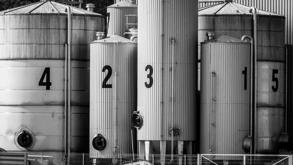 Black and white photo of five large industrial silos numbered 4, 2, 3, 1, and 5 in a row.