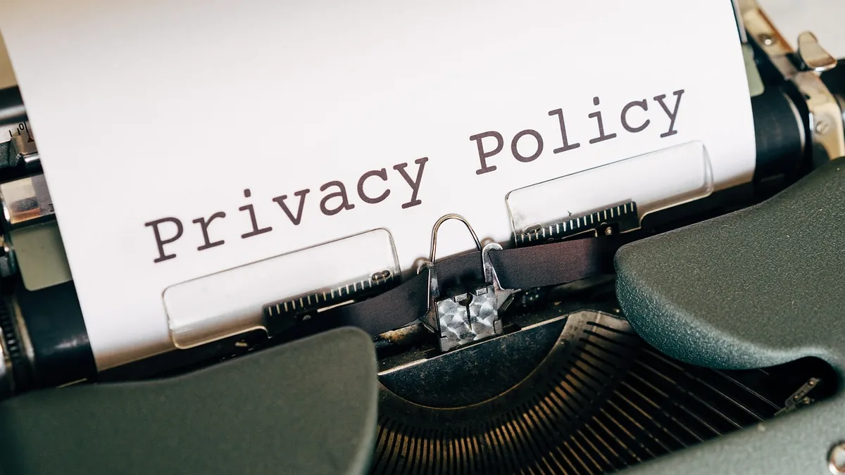 A close-up shot of a vintage typewriter with a sheet of paper displaying the typed words 'Privacy Policy'.