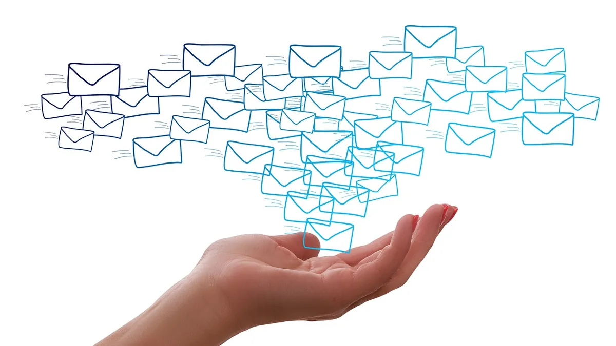A hand releasing a stream of blue-drawn email envelopes flying upwards against a clean white background.