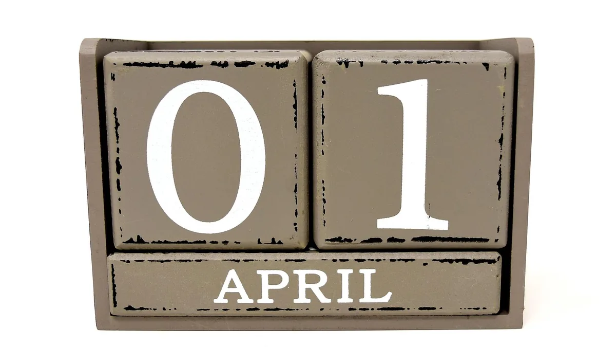 A wooden block calendar displaying the date '01 APRIL' in a rustic grey wooden frame.