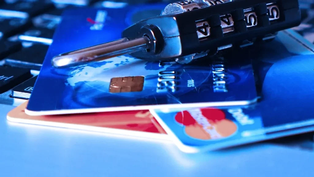 Combination padlock on credit cards over a keyboard, symbolizing financial data security and cyber threats.