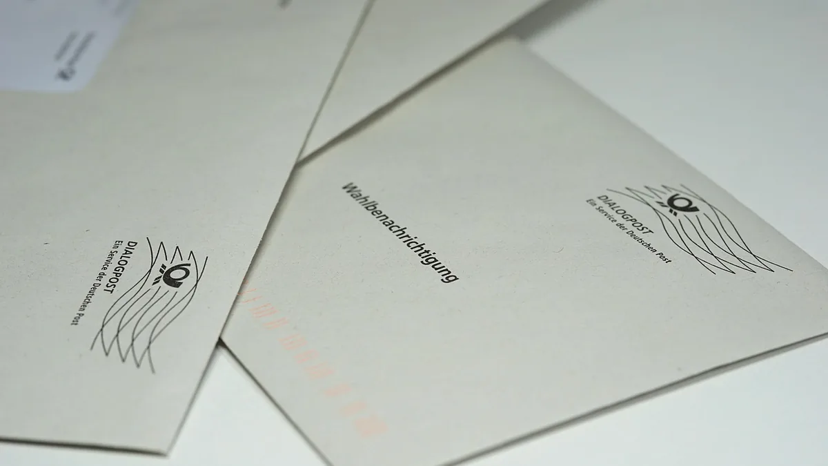 Grey envelopes with German text 'Wahlbenachrichtigung' and the Dialogpost logo, representing official notification letters.