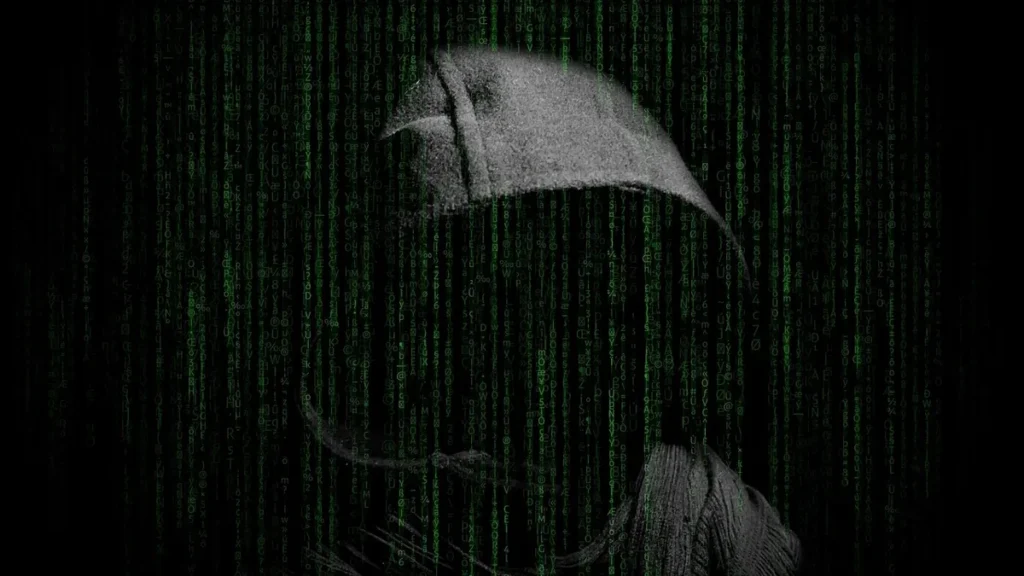 A hooded figure shrouded in green digital matrix code on a black background, representing a cyber hacker.