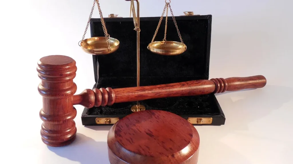 Wooden gavel and brass scales of justice symbolizing law, legal justice, and court authority.