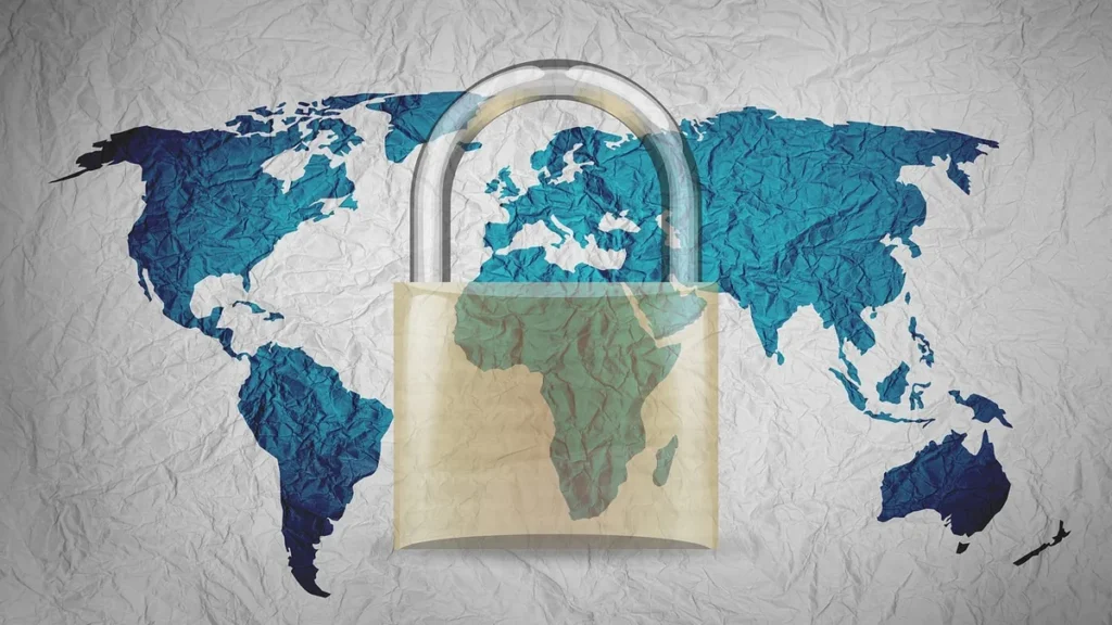 A padlock over a blue crumpled world map on white textured paper, representing global cybersecurity.