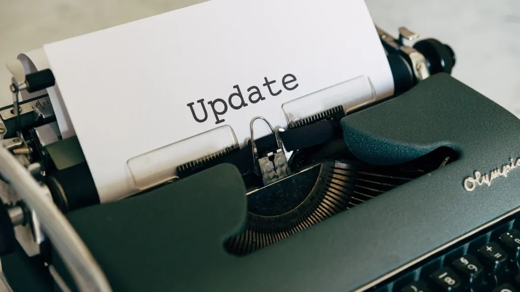 A vintage typewriter with a sheet of paper showing the typed word 'Update'.
