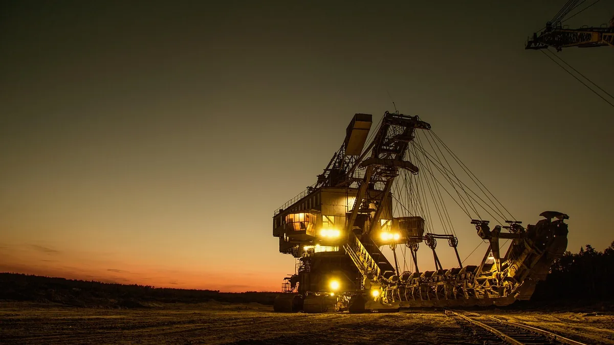 Large mining excavator illuminated at dusk, symbolizing massive industrial-scale data extraction.