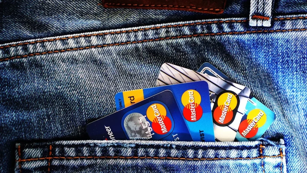 Cropped view of multiple Mastercard credit cards sticking out of a blue denim pocket.