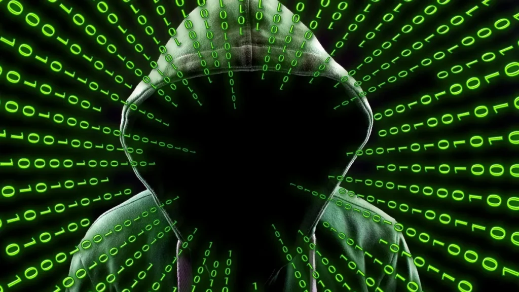 A hooded figure with a shadowed face surrounded by radiating green binary code.