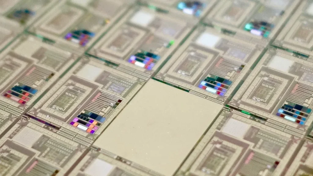Macro view of a silicon wafer showing colorful, intricate microchip circuit patterns with a shallow depth of field.