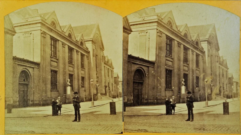 Historic stereocard showing the grand facade of the University of Copenhagen with figures standing on the street in front.