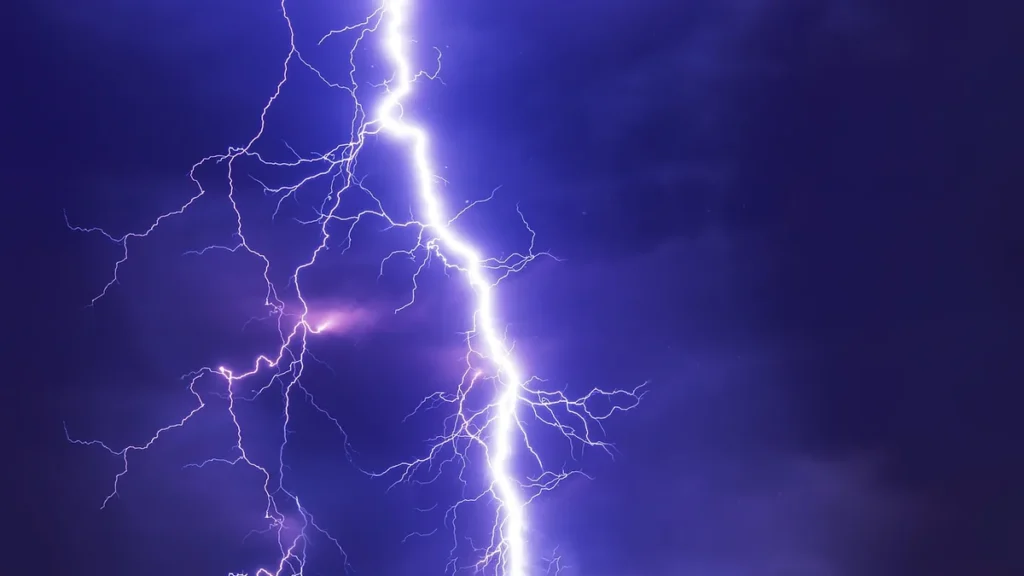 A bright purple lightning bolt branching across a dark, stormy purple sky.